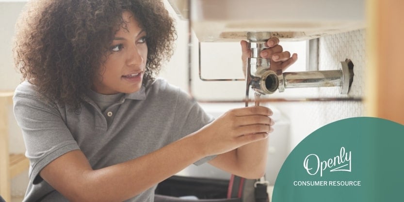 A woman repairs sink plumbing. 