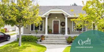 A one story gray house is situated at the end of a path.