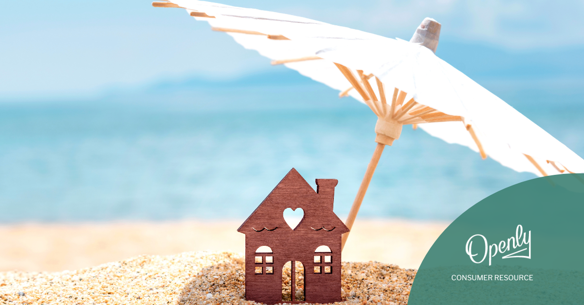 An umbrella shades a wooden house on the beach. 